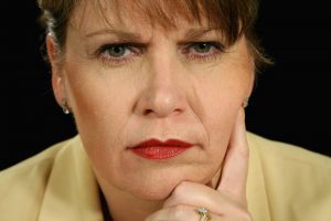 An image of a woman scowling, an example of a bad expression to make in a LinkedIn headshot.