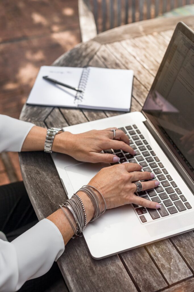 person on computer with journal 