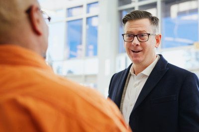A stock photo of two men in business having a conversation, illustrating the power of a personal connection instead of a cold letter of interest.