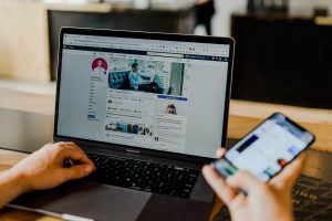 Person using both laptop and smartphone. Photo by Austin Distel on Unsplash