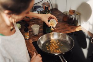 Person holding stainless steel pan with food. Photo by Conscious Design on Unsplash