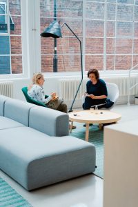 two women sitting. Photo by Toa Heftiba on Unsplash