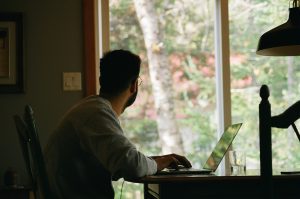 Man looking out window. Photo by Yasmina H on Unsplash