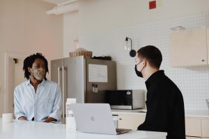 Two workers in face masks. Photo by Good Faces on Unsplash