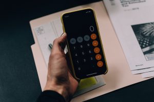 Bills and calculator. Photo by Kelly Sikkema on Unsplash