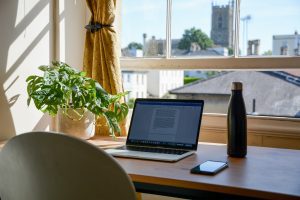 Computer on desk in front of window. Photo by Mikey Harris on Unsplash