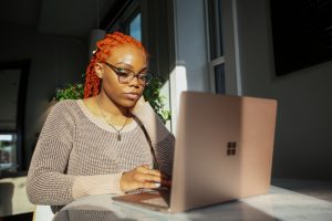 woman using resume screening software on computer. Photo by Surface on Unsplash