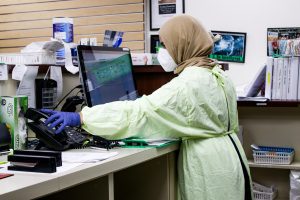 Nurse in headscarf standing at a desk. hoto by Jakayla Toney on Unsplash