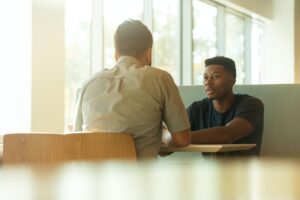 man sitting across the table from another man